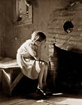 1930's America, resettled farm child girl staring into fireplace