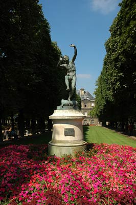 Park in Paris, red flowers, sculpture